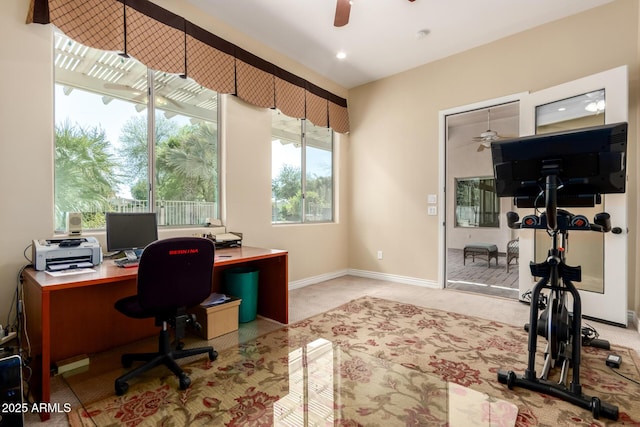 office space with ceiling fan, light carpet, and baseboards