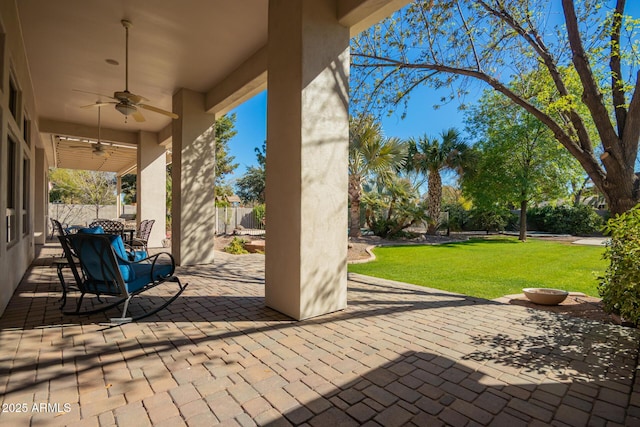 view of patio featuring ceiling fan and fence