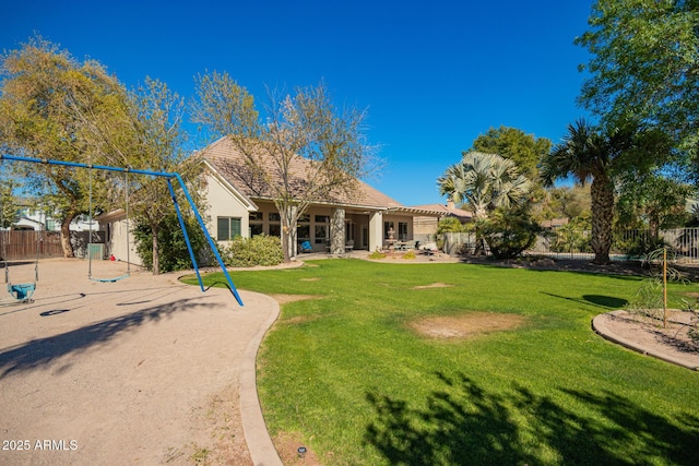 back of property featuring a patio, a lawn, a playground, and fence