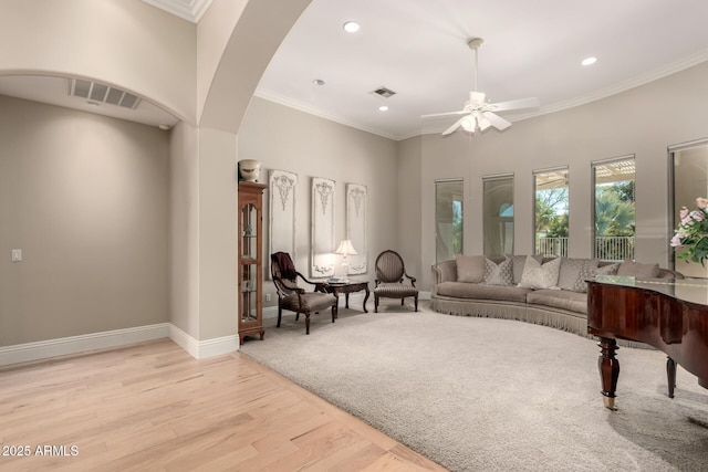 sitting room featuring ornamental molding, light wood-style flooring, visible vents, and baseboards