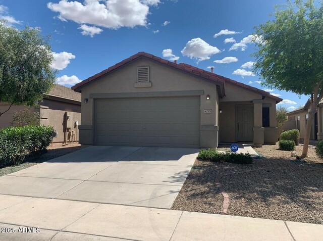view of front of home with stucco siding, driveway, an attached garage, and a tiled roof