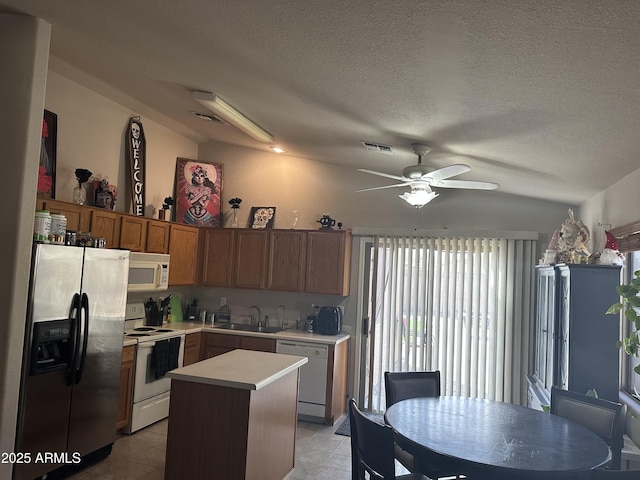 kitchen with white appliances, visible vents, ceiling fan, a sink, and light countertops