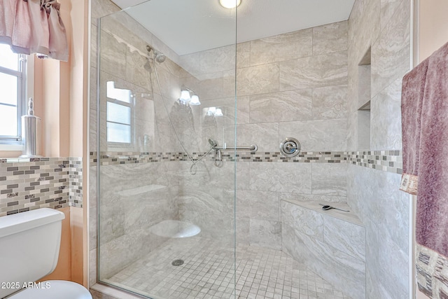 bathroom with a shower with shower door, tile walls, and toilet