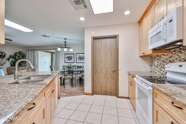 kitchen with white appliances, sink, decorative light fixtures, light brown cabinets, and tasteful backsplash