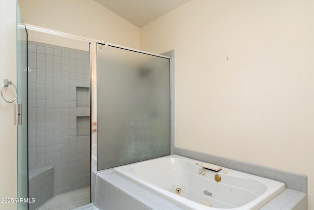 bathroom featuring a stall shower and a tub with jets