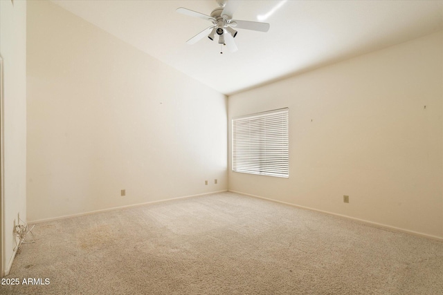 empty room featuring light carpet, ceiling fan, lofted ceiling, and baseboards