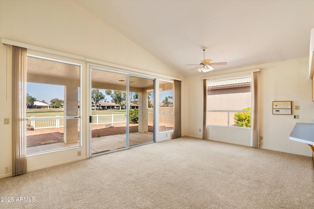 carpeted spare room with lofted ceiling, ceiling fan, and baseboards