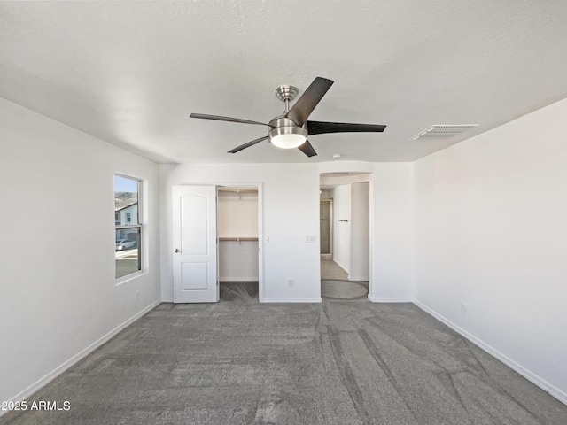 unfurnished bedroom with a closet, visible vents, a ceiling fan, carpet flooring, and baseboards