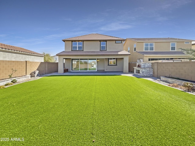 back of house with a yard, a fenced backyard, a patio area, and stucco siding