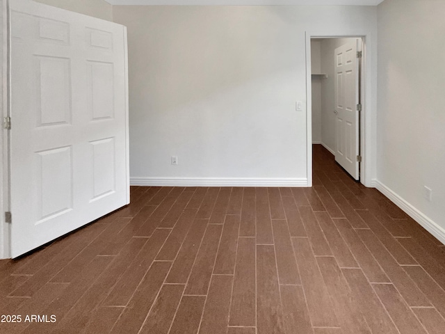 unfurnished bedroom with dark hardwood / wood-style floors, a spacious closet, and a closet