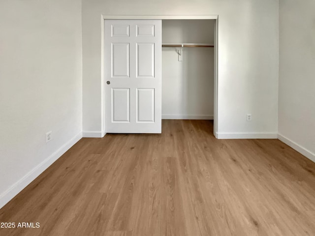 unfurnished bedroom featuring light wood-type flooring and a closet