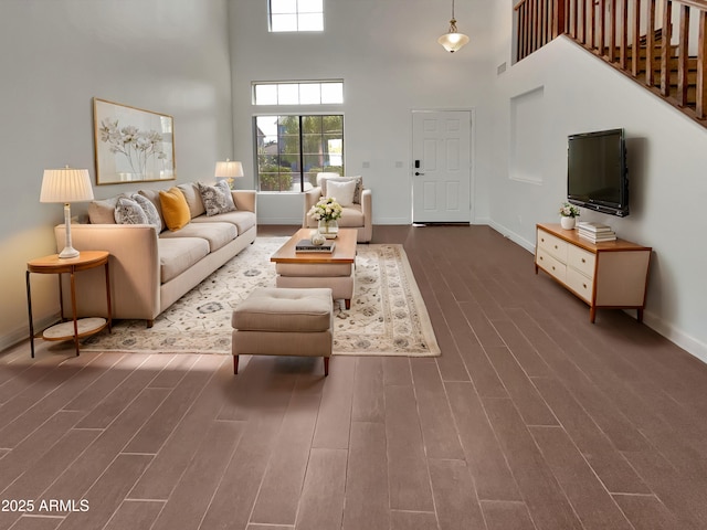 living room featuring dark hardwood / wood-style flooring and a towering ceiling