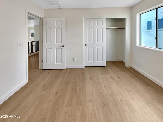 unfurnished bedroom with a closet and light hardwood / wood-style flooring