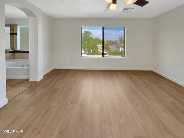 unfurnished room with ceiling fan and light hardwood / wood-style floors