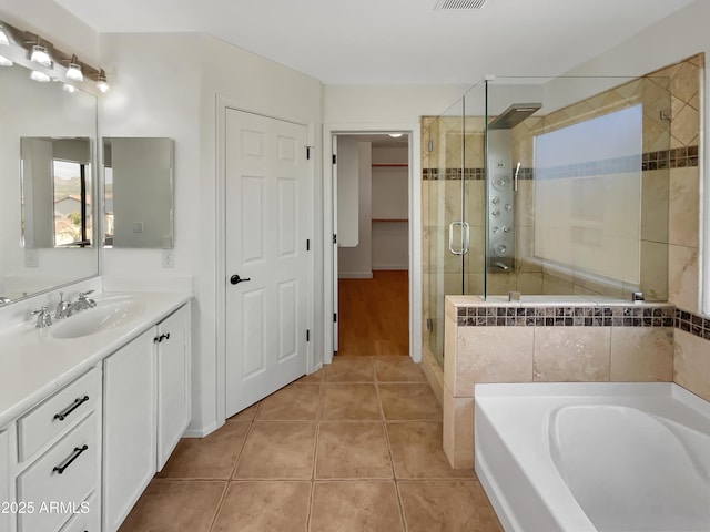 bathroom with tile patterned floors, vanity, and separate shower and tub