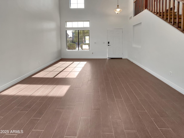 foyer entrance featuring dark hardwood / wood-style flooring and a towering ceiling