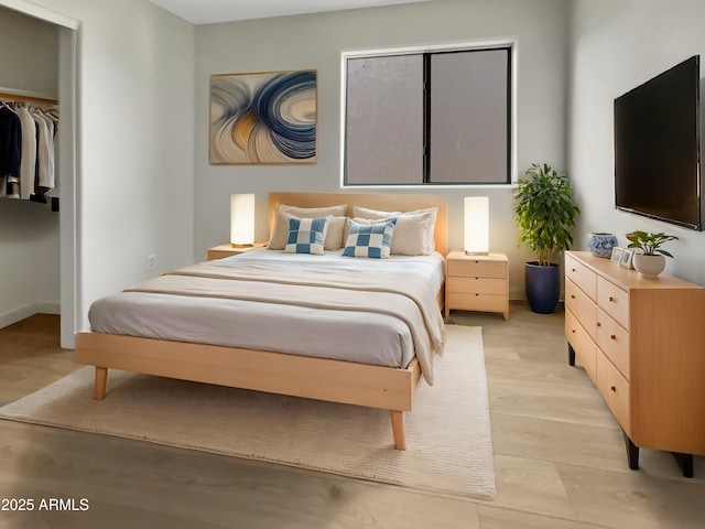 bedroom with light hardwood / wood-style floors and a closet