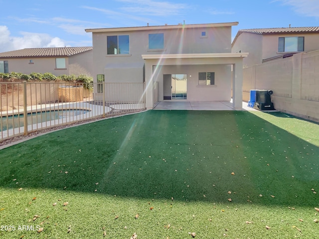 back of house featuring a yard, a patio, and a fenced in pool