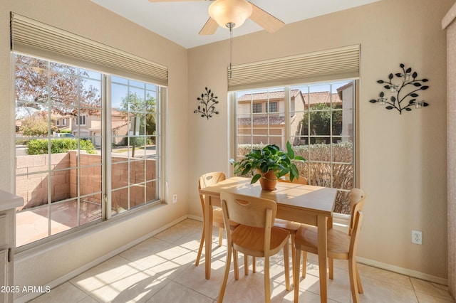 dining area featuring light tile patterned floors, baseboards, and a ceiling fan