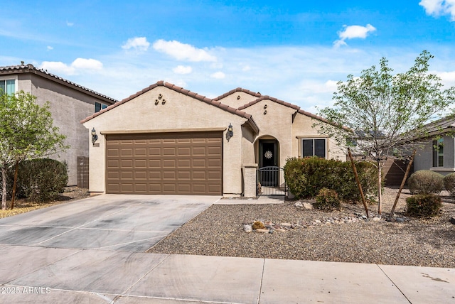 mediterranean / spanish home with an attached garage, driveway, a tiled roof, a gate, and stucco siding