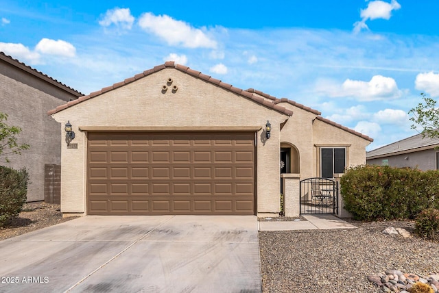 mediterranean / spanish home with driveway, an attached garage, a gate, and stucco siding