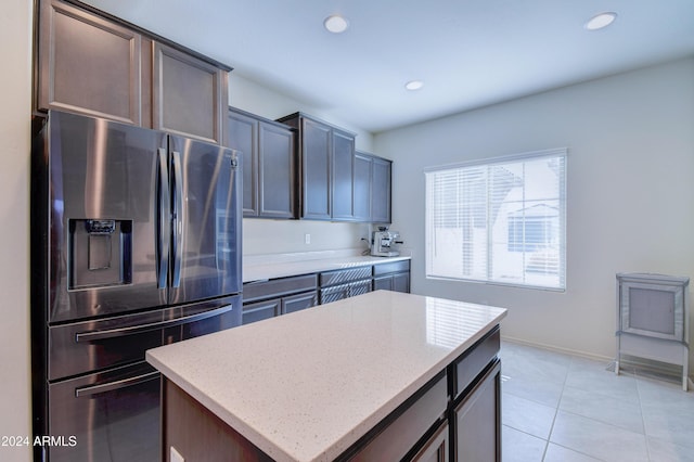 kitchen with dark brown cabinetry, a center island, light tile patterned floors, and stainless steel refrigerator with ice dispenser