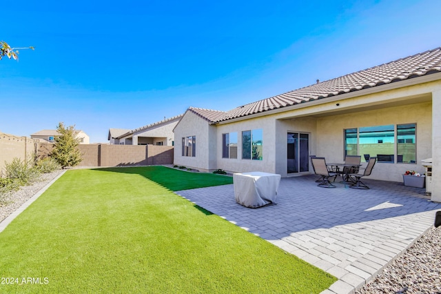 rear view of house featuring a patio and a lawn