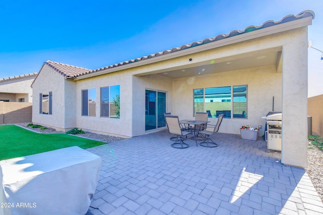 rear view of property with a patio area and a lawn