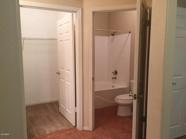 full bathroom featuring toilet, tile patterned flooring, a spacious closet, and  shower combination