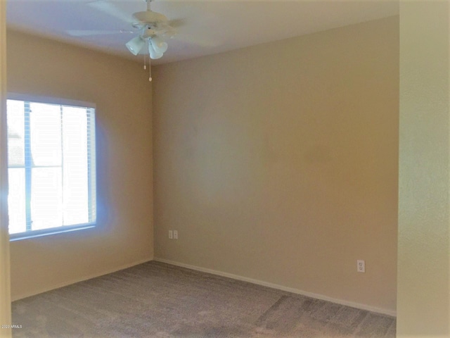 carpeted empty room with a ceiling fan