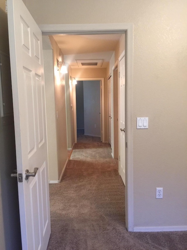 corridor featuring attic access, carpet flooring, visible vents, and baseboards