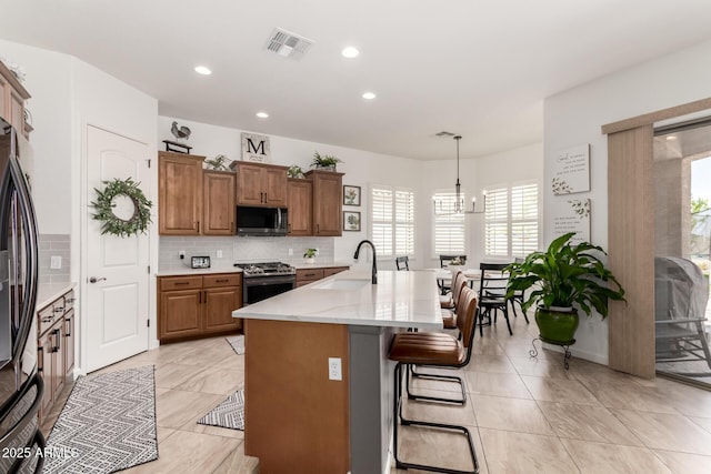 1804 W Magdalena Ln, Phoenix, AZ 85041 - kitchen featuring a sink, appliances with stainless steel finishes, plenty of natural light, brown cabinets, and recessed lighting
