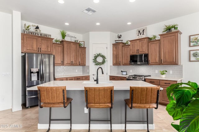 1804 W Magdalena Ln, Phoenix, AZ 85041 - kitchen with stainless steel refrigerator with ice dispenser, range, light countertops, a breakfast bar area, and recessed lighting