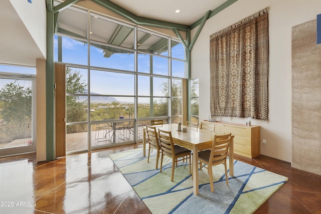 dining space featuring a wall of windows and a towering ceiling