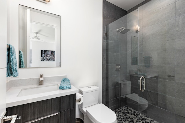 bathroom with ceiling fan, vanity, toilet, and an enclosed shower