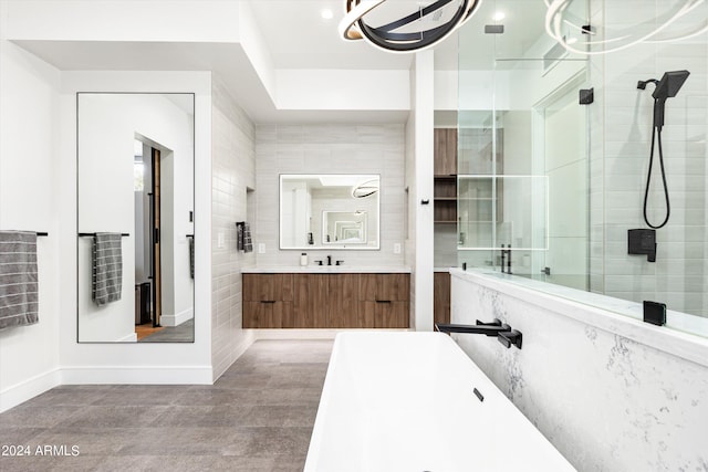 bathroom with tile walls, vanity, and a shower with door