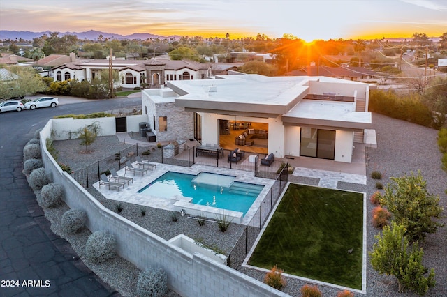 back house at dusk featuring a patio