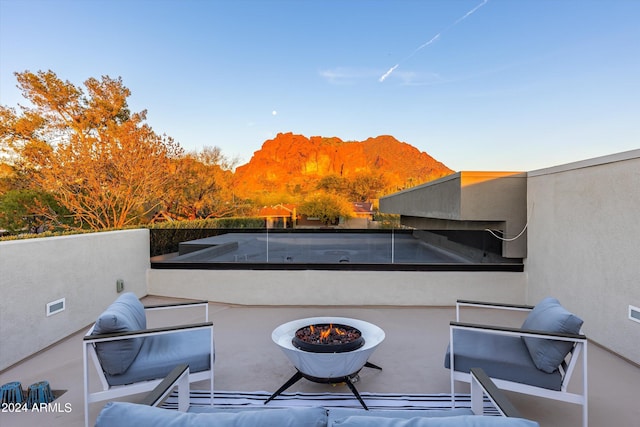 view of patio with an outdoor fire pit and a mountain view