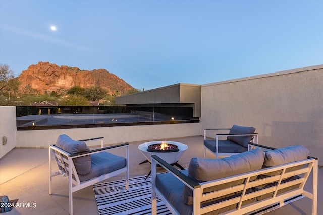 view of patio / terrace with a mountain view and an outdoor living space with a fire pit