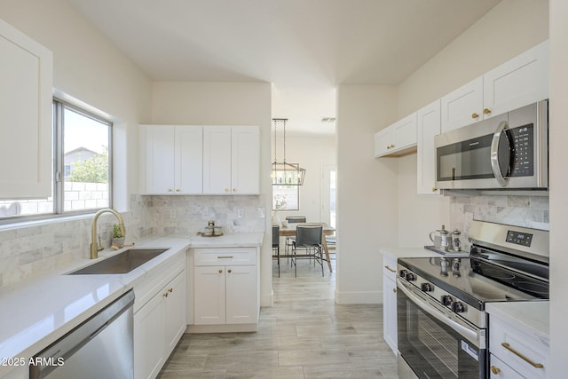 6731 W Northview Ave, Glendale, AZ 85303 - kitchen featuring appliances with stainless steel finishes, tasteful backsplash, a sink, and white cabinetry