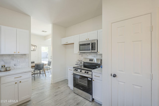 6731 W Northview Ave, Glendale, AZ 85303 - kitchen featuring stainless steel appliances, visible vents, backsplash, white cabinetry, and light countertops