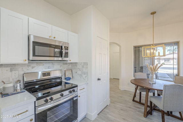 6731 W Northview Ave, Glendale, AZ 85303 - kitchen featuring a notable chandelier, decorative backsplash, appliances with stainless steel finishes, and white cabinetry