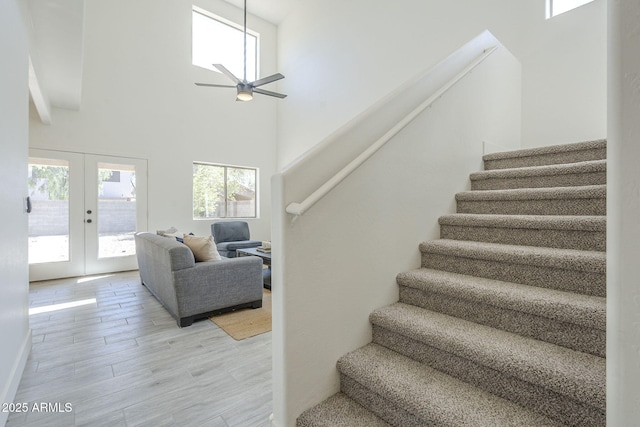 6731 W Northview Ave, Glendale, AZ 85303 - stairs featuring wood finished floors, a high ceiling, a ceiling fan, and french doors