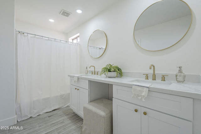 6731 W Northview Ave, Glendale, AZ 85303 - bathroom with recessed lighting, double vanity, visible vents, wood finished floors, and a sink