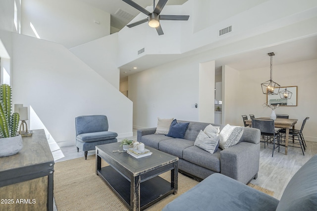 6731 W Northview Ave, Glendale, AZ 85303 - living room with ceiling fan with notable chandelier, visible vents, and light wood finished floors