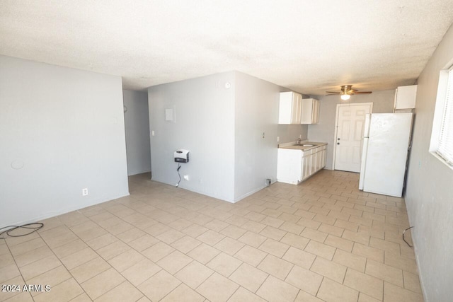 interior space featuring a textured ceiling, ceiling fan, and sink