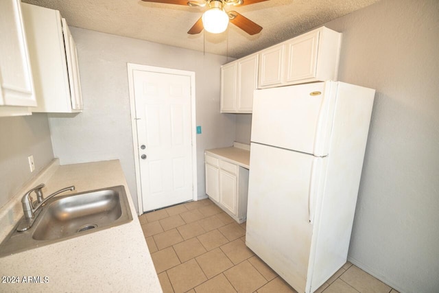 kitchen featuring a textured ceiling, sink, white cabinetry, ceiling fan, and white refrigerator