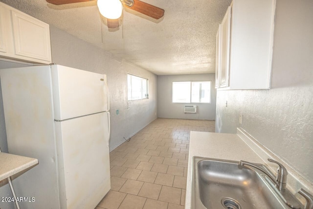 kitchen with a textured ceiling, sink, white cabinetry, ceiling fan, and white refrigerator