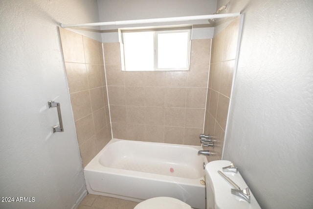 bathroom with tiled shower / bath combo, toilet, and tile patterned flooring