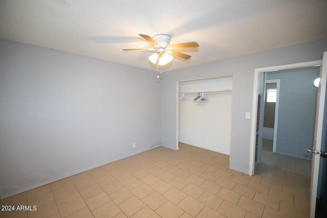 unfurnished bedroom with a textured ceiling, ceiling fan, and a closet